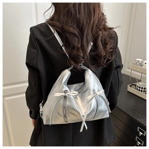 Silver metallic bow backpack detail showing shiny faux leather texture and zipper design