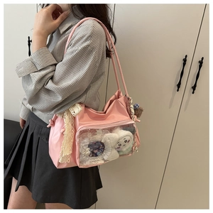 Pink Ita bag with clear PVC window showing plush charms and pins, stylish shoulder strap