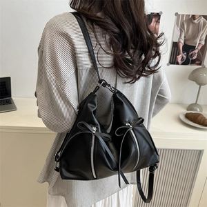 Chic black bow knot tote backpack with dual zippers for women in a lifestyle indoor setting