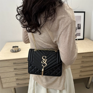 Elegant black leather quilted shoulder bag with gold S-buckle and tassel detail