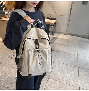 Detail view of the large capacity nylon backpack with front buckle pocket and drawstring