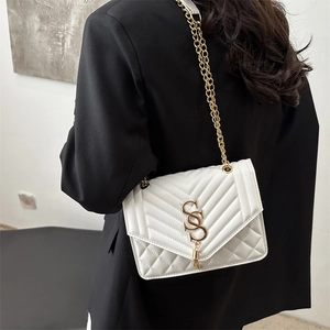 Minimalist white quilted shoulder bag with gold chain and SS logo on black blazer