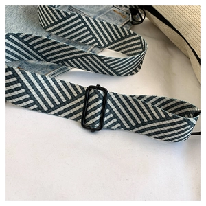 Detail of wide geometric woven strap with black metal buckle on corduroy pillow bag