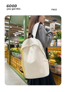 Detailed view of a white nylon backpack featuring 'Y' embroidery and 'DAY' label details