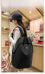 Detailed view of black nylon backpack with durable waterproof fabric and white Y-shaped logo