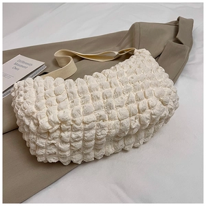 Close-up of the bubble texture and soft fabric on this cream white crossbody tote bag