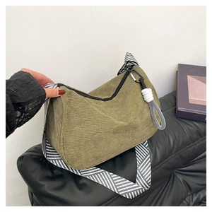 Detail of green corduroy shoulder bag with geometric pattern strap and rope knot zipper pull