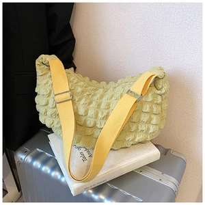 Detailed macro shot of bright yellow cloud bag texture and adjustable strap on a suitcase