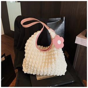 Détail du sac cabas gaufré blanc avec bandoulière rose et breloque en forme de fleur