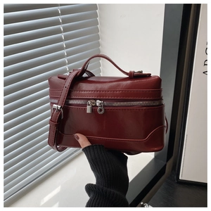 Detailed macro of dark red patent leather handbag with silver lock and double zipper
