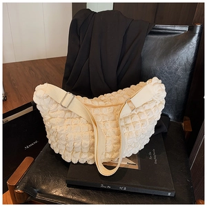 Adjustable canvas strap and puffy textured fabric of this cream cloud shoulder bag