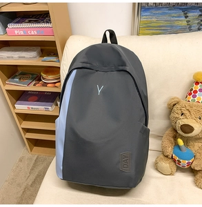 Detail of waterproof nylon backpack featuring embroidered Y letter and DAY leather patch