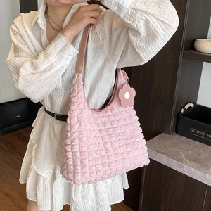 Sac fourre-tout rose à texture gaufrée avec pendentif fleur porté par un mannequin