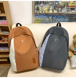 Detailed view of color-block nylon backpacks with Y logo and leather patch accents