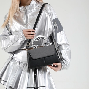 Fashionable black leather crossbody bag with unique liquid metal handle worn by model