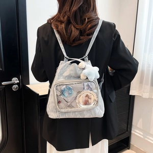 Silver nylon ita bag with transparent PVC window and star plush charm on a model