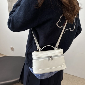 Minimalist white leather square crossbody bag with silver zippers and top handle