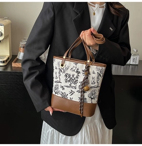 Détail du sac seau en toile avec broderie chinoise et finitions en cuir marron