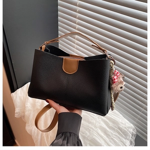 Détails du sac seau en cuir grainé avec poignées marron et charmant petit ours