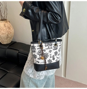 Détail du sac seau en toile avec broderie paysage chinois et pendentif cloche