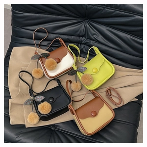 Detail shot of stylish crossbody bags in four colors with cherry pompom charm and fine straps
