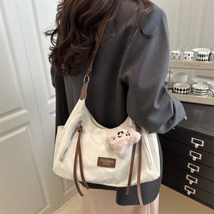 Borsa a spalla capiente beige e marrone con un grazioso ciondolo in peluche rosa