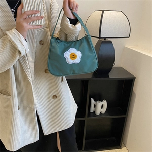Minimalist green baguette bag with sunflower smile patch and top handle for women