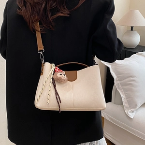 Sac seau minimaliste beige avec poignées marron et porte-clé singe en peluche