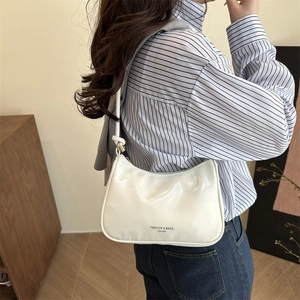Minimalist white leather hobo underarm bag with black lettering and sleek shoulder strap