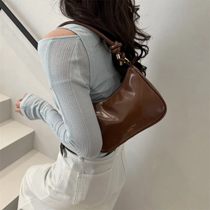 Brown leather hobo shoulder bag with stylish knotted strap and gold metallic details
