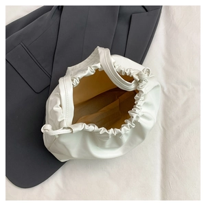 Vista dall'alto dell'interno della borsa a secchiello arricciata bianca con coulisse su blazer