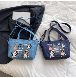 Detail of cartoon denim tote bags in light and dark blue with adjustable straps