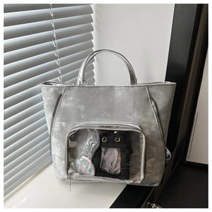 Macro detail of silver tote bag with transparent display window and metallic texture