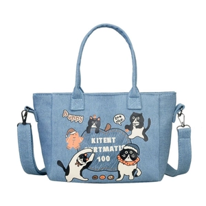 Blue denim tote bag with cute cartoon cat illustrations and adjustable shoulder strap