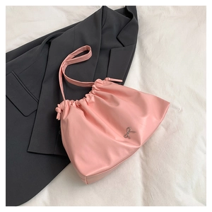 Dettaglio della borsa a secchiello rosa con coulisse e fiocco decorativo in metallo argento