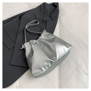 Dettaglio borsa tote argento metallizzato con pieghe a coulisse e fiocco in metallo su blazer
