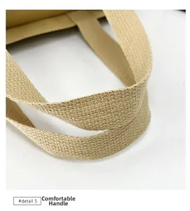 Detail shot of sturdy woven handles on a beige canvas tote with comfort grip texture
