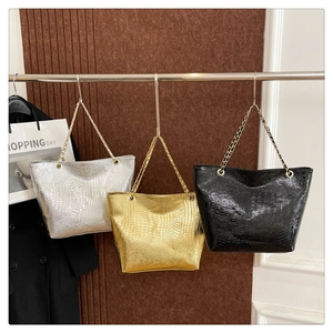 Three crocodile embossed tote bags in silver gold and black with metal chain straps
