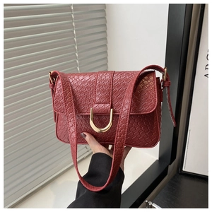 Détail du sac à main rouge foncé motif crocodile avec fermoir métallique doré en U