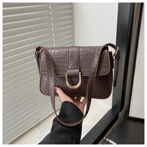 Détail du sac rétro à motif pierre marron avec fermoir métallique doré en forme de D