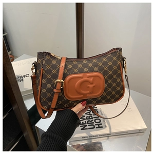 Detail van vintage geruit patroon en lederen G-patch op een donkerbruine handtas voor dames