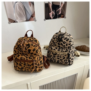 Detail of trendy corduroy leopard print backpacks in brown and beige with zip pockets