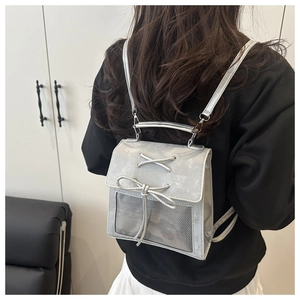 Silver mini backpack with cross lace-up bow and grey mesh panel details shown on model