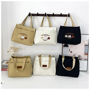 Detail of small canvas tote bags with bear embroidery and sport leather tags