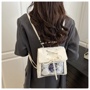 Detailed view of the white ita bag with transparent window and lace bow decoration