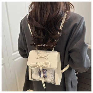 Detail of white leather ita bag featuring a transparent window with lace and bow