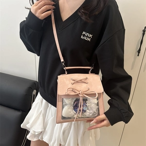 Pink ita bag with transparent window and bow decoration shown on a model