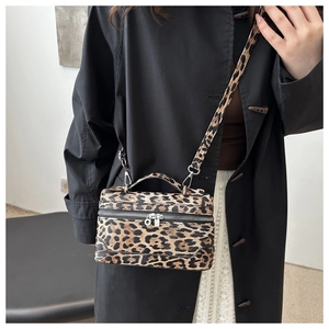 Détail du sac boîte vintage à motif léopard avec garnitures argentées sur un mannequin femme