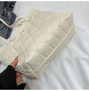 Détail du sac cabas matelassé blanc crème montrant la texture douce et les coutures