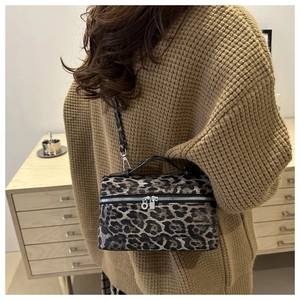 Vue détaillée du sac boîte vintage à motif léopard porté en bandoulière sur un tricot